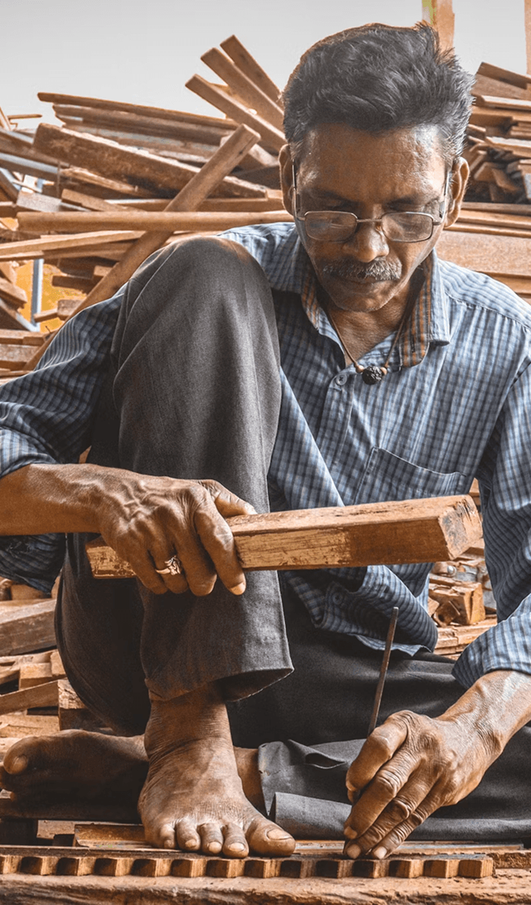 Traditional Indian carpenter working on floor with hand tools